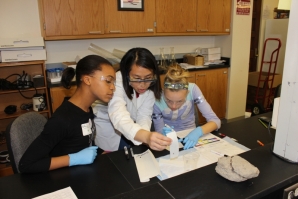 Jennifer Lee, a graduate student from Penn, explains an experiment to two girls during the conference.