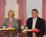 Jodie King Smith, vice president of enrollment management, and Michael Gomez, principal of Cristo Rey Philadelphia, sign the partnership agreement.